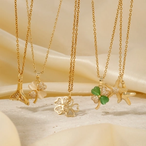 Elegant gold pendant necklaces featuring clover, fishtail, and starfish designs on silk