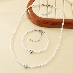 Elegant white glass pearl necklace and bracelet set with a silver girl-shaped pendant