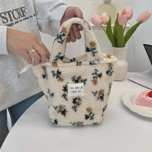 Nahaufnahme der floralen Plüsch-Tragetasche mit Lammfell-Textur und Marken-Stoffetikett