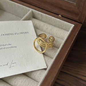 Close-up of golden multi-layer intertwined open ring inside a wooden jewelry box