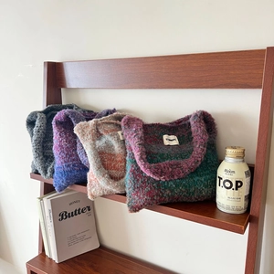 Detail of colorful gradient knit tote bags with brand label and plush texture material