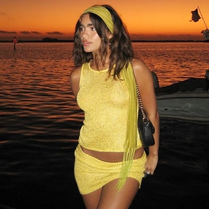Detail of yellow knitted two-piece set featuring sleeveless top and skirt for vacation wear