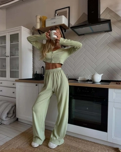 Detail of light green ribbed knit lounge set featuring cropped cardigan and wide-leg pants