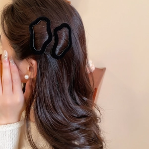 Detail of black velvet irregular hair clips worn by a model for a soft aesthetic look