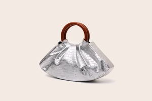 Detail of silver crocodile texture handbag with round wooden handle and pleated cloud design