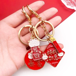 Detailed view of red enamel Chinese New Year alloy charms with cat and persimmon motifs
