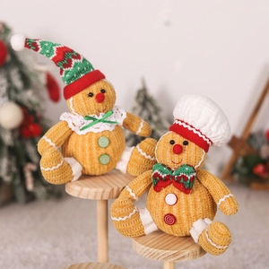 Gingerbread man pluche poppen met koksmutsen en kerstdecor op houten plateau