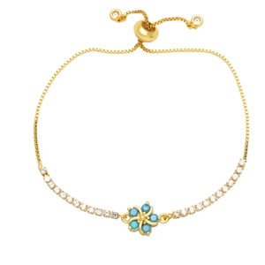 Adjustable gold plated flower bracelet featuring blue gemstones and white cubic zirconia