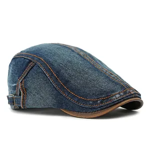 Retro washed denim flat cap in dark blue with orange stitching and brown leather visor detail