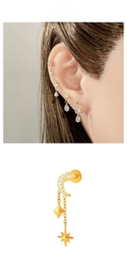 Macro detail of F136 titanium gold star and moon cartilage earring with cubic zirconia
