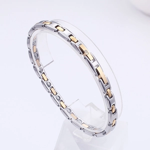 Detail of silver and gold stainless steel magnetic bracelet with germanium stone inserts