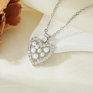 Detail of silver heart pendant featuring sparkling zircon micro-pave and white pearls