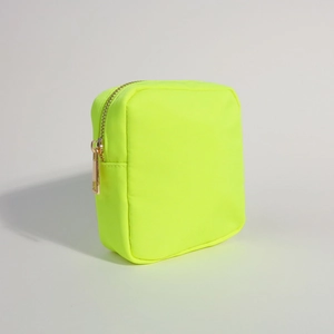 Detail of neon green nylon makeup bag with a high-quality gold zipper closure