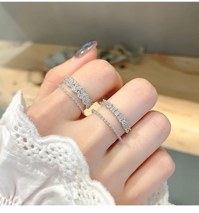 Close-up of silver zircon rings set with intricate petal design and lace sleeve detail
