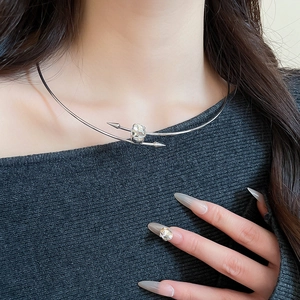 Detailed view of silver oval crystal choker necklace with minimalist arrow design on neck