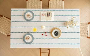 Detailed texture of American retro cream tablecloth with blue geometric embroidery patterns