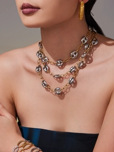 Vue détaillée d'un collier à maillons grains de café plaqué or 18 carats sur un modèle