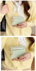Detail of light green PU leather coin purse with gold zipper and keychain held by model