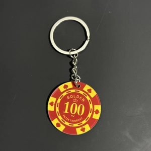 Detail of red and yellow poker chip keychain with 100 value and poker suit icons