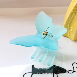 Detail of light blue butterfly claw clip showing matte texture and metal spring