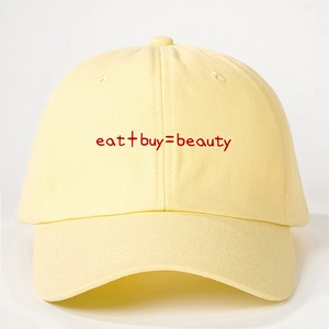 Cremefarbene Baumwoll-Basecap mit roter 'eat + buy = beauty' Stickerei auf weißem Hintergrund