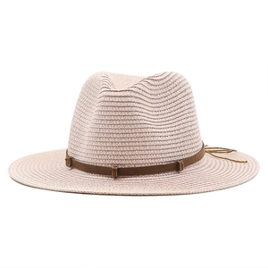 Close-up of beige woven straw cowboy hat with a dark brown faux leather decorative band