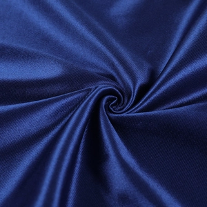 Gros plan sur la texture du tissu satiné bleu foncé brillant aux plis soyeux élégants