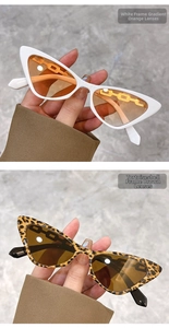 Close-up of cat-eye sunglasses with gold chain accents in white and tortoiseshell frames