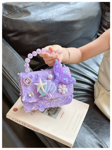 Dettaglio borsa da principessa sirena con pizzo lilla, manico di perle e decori marini