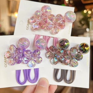 Detailed set of three high-elastic camellia hair ties in pink, purple, and taupe