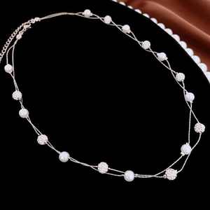 Detail of double-layer silver necklace with white pearls and sparkling crystal balls