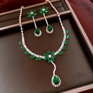 Luxury flower jewelry set with emerald green stones and white zircon crystals on a velvet tray
