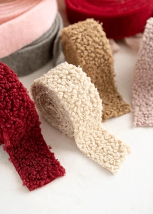 Detailed close-up of colorful teddy wool felt ribbons for DIY Christmas tree decorations