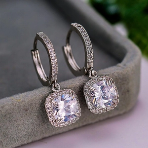 Macro shot of silver drop earrings featuring cushion-cut cubic zirconia and pave details