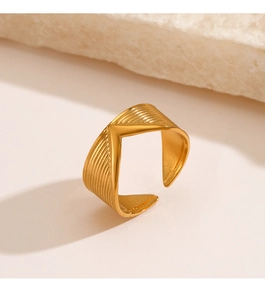 Detail shot of the golden V-shaped ring showing fine horizontal striped texture