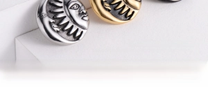 Macro shot of sun and moon face reliefs on vintage gold and silver titanium steel pendants