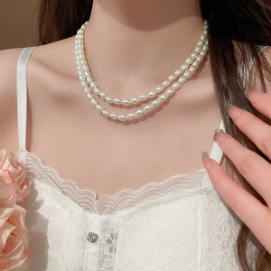 Close-up of double-layer white oval pearl necklace on neck for a delicate French chic look