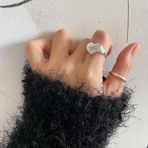 Detail of 925 sterling silver heart ring with 'Love' engraving on model's hand