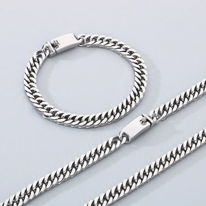 Detailed view of stainless steel Cuban chain necklace and bracelet set in silver finish