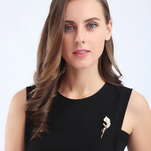 Detail of rose gold calla lily brooch with zircon inlay on elegant black dress