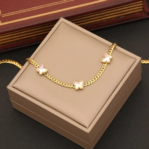 Elegant gold butterfly pendant bracelet on a jewelry box with white wing details