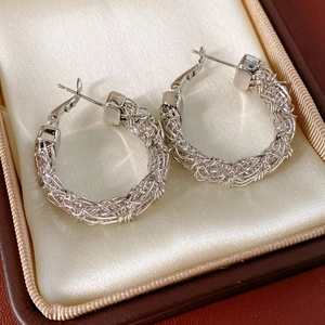 Detail of silver woven mesh hoop earrings presented in a luxury jewelry gift box