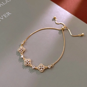 Detail of gold clover bracelet featuring micro-pave crystals and adjustable slider clasp