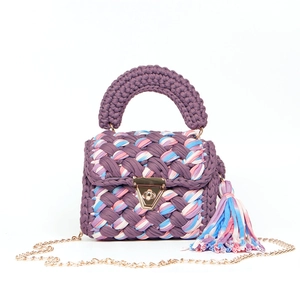 Detail of purple handmade crochet bag with golden triangular lock and colorful tassels