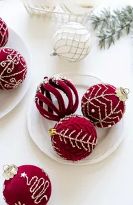 Vue macro de boules de Noël en velours bordeaux avec paillettes dorées et motifs