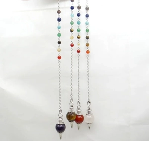 Detailed view of four natural crystal pendulum pendants with colorful chakra stone beads
