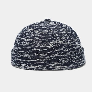 Detail of vintage washed denim brimless docker hat in dark blue snowflake pattern
