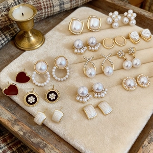 Vintage French pearl and diamond fishtail earrings set displayed on beige velvet
