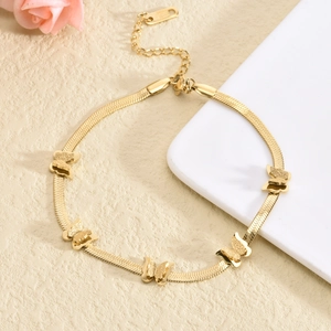 Flat gold snake chain bracelet featuring five butterfly charms on textured pedestal