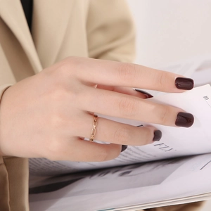 Close-up of a gold chain-link stainless steel ring worn on index finger with a modern style